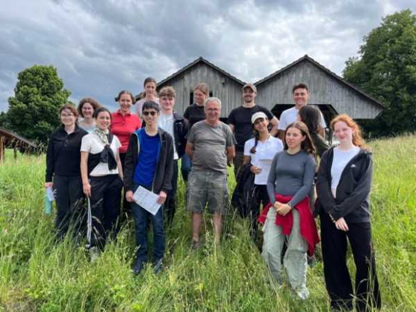 Group picture in a grassland in front of a barn
