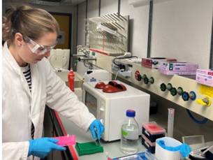 Woman in lab coat sorting small plastic tubes in a lab