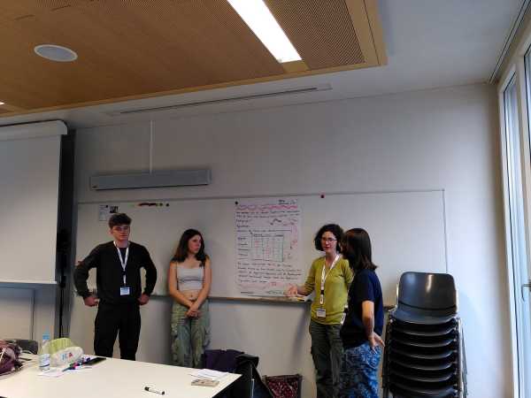 Four people presenting a hand-written poster