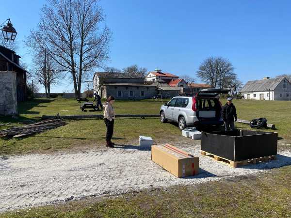 People moving around between boxes, houses in the background