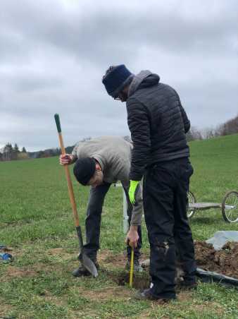 Two men digging a hole in the soil