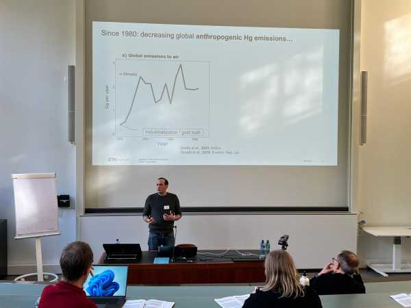 Man standing in front of screen in a lecture hall