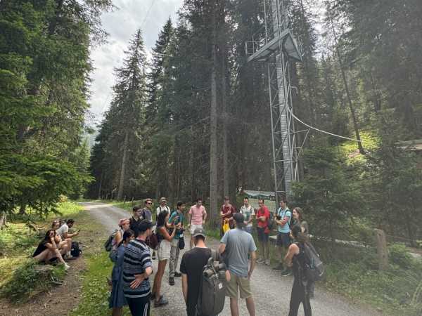 Group of people standing next to tall tower, explaining something