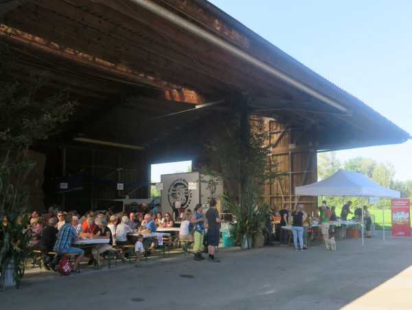 People sitting at tables in a barn
