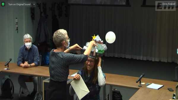 Enlarged view: Supervisor putting doctoral hat on head of candidate