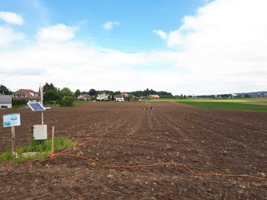 Enlarged view: Bare field with measurement set up and a cable laying on the ground