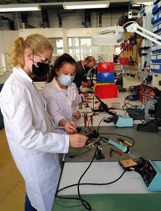 Two girls soldering in a workshop