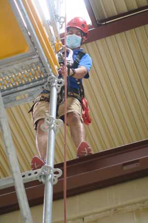 Man in climbing gear on scaffold