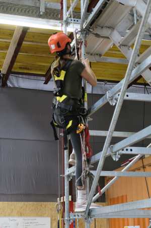 Woman climbing on a scaffold in climbing gear