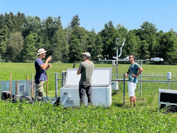 Three men around a box in the field