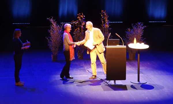 Woman and man shaking hands on a stage