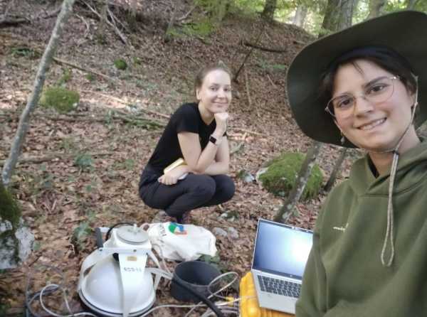 Two women around a measurement device