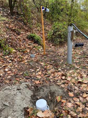 Grey plastic tube in soil, passive sampler in hole in soil, sampler on wodden pole