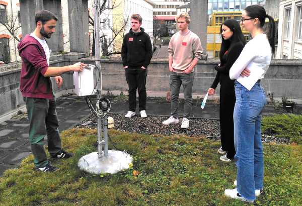 Three men and two women standing around a pole with instrumentation