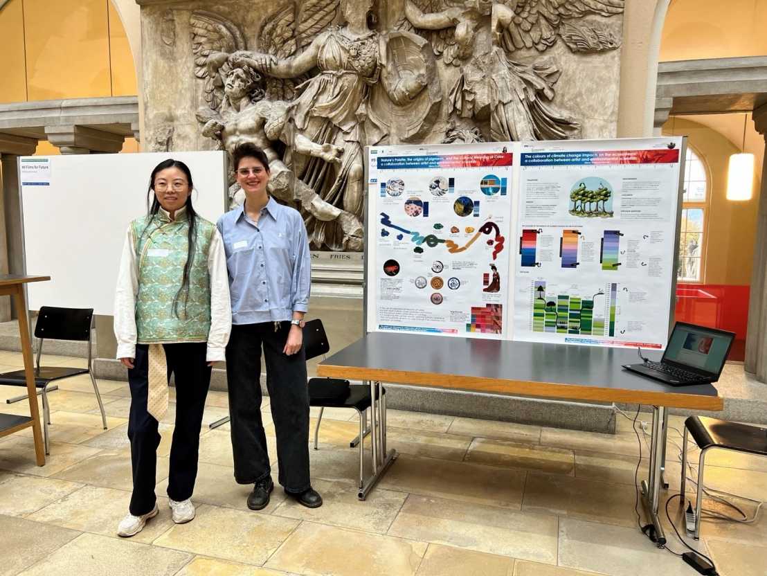 Enlarged view: Two women standing next to colorful posters